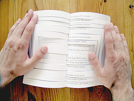 Photograph of a palindromic sonnet — two page spread, with diecuts — in a physical book